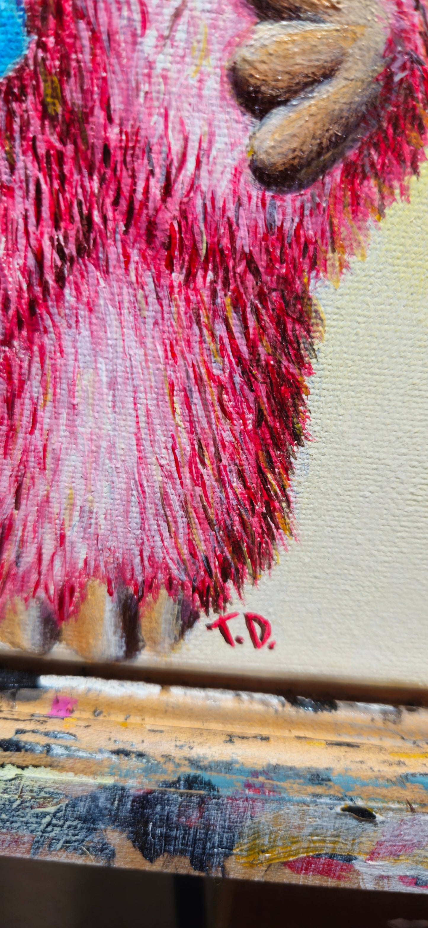 Close-up of a textured pink and brown surface with 'T.D.'