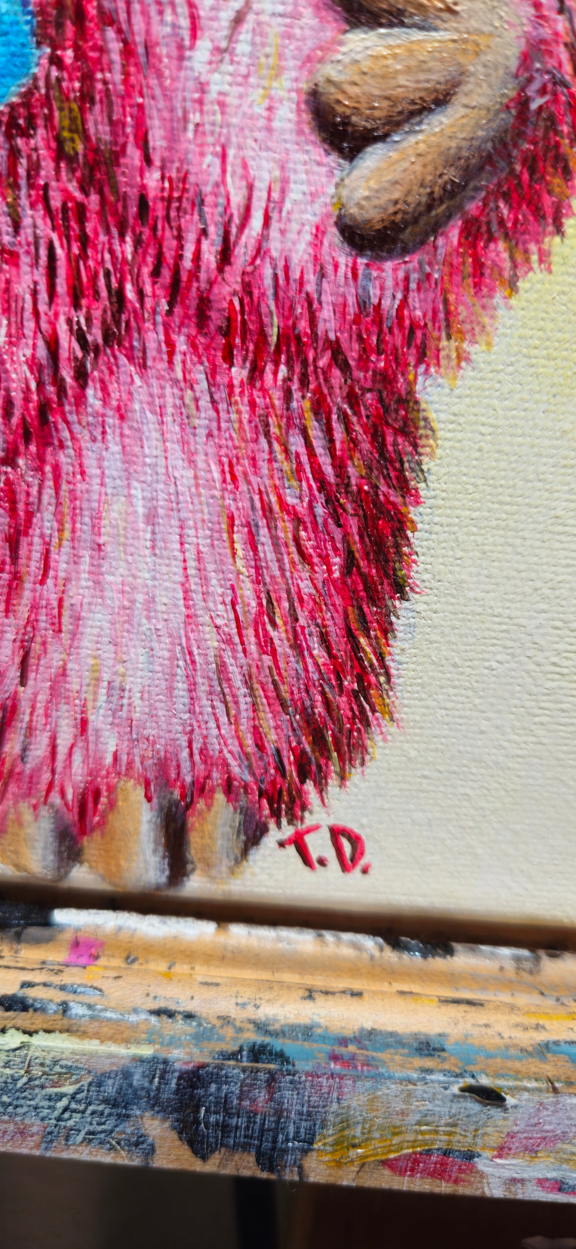Close-up of a textured pink and brown surface with 'T.D.'